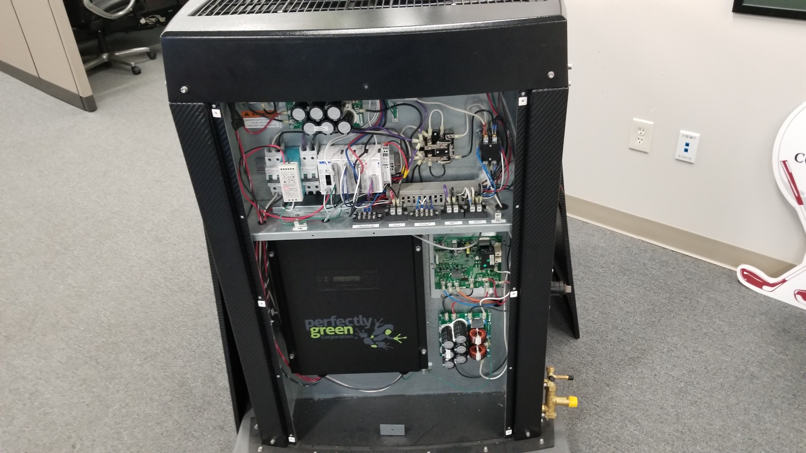 Open Perfectly Green energy-control cabinet showing wiring, controls and circuit boards